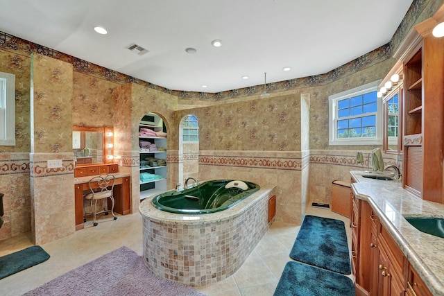 bathroom featuring visible vents, tile walls, tile patterned flooring, vanity, and a bath