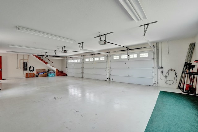 garage featuring electric panel and a garage door opener