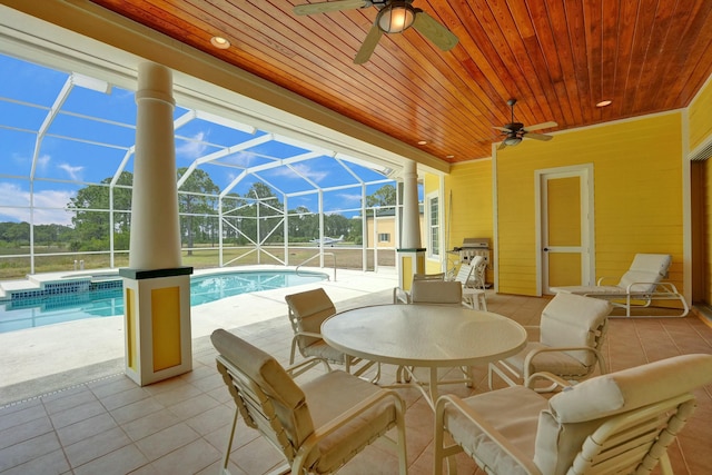 pool featuring glass enclosure, a patio, and ceiling fan