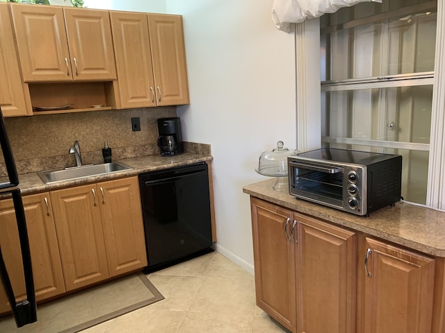 kitchen with light tile patterned floors, black dishwasher, a toaster, tasteful backsplash, and a sink