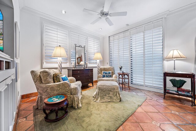 living area featuring baseboards, ornamental molding, a ceiling fan, and tile patterned floors