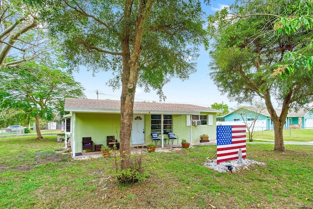 rear view of house featuring a lawn and stucco siding