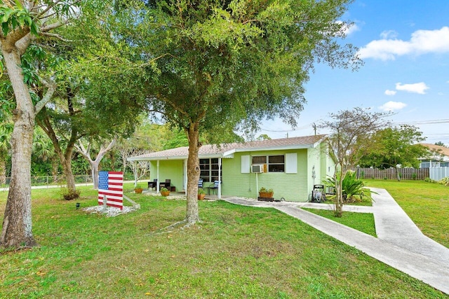 view of front facade with a front lawn, cooling unit, and fence