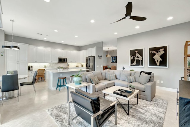 living room with ceiling fan, baseboards, and recessed lighting