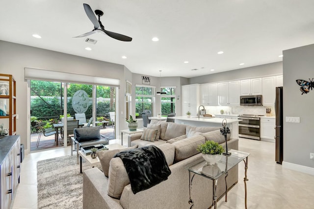 living area with baseboards, visible vents, ceiling fan, and recessed lighting