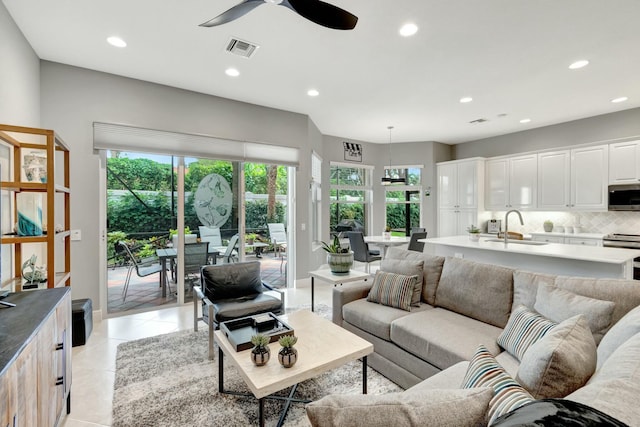 living room with light tile patterned floors, ceiling fan, recessed lighting, visible vents, and baseboards