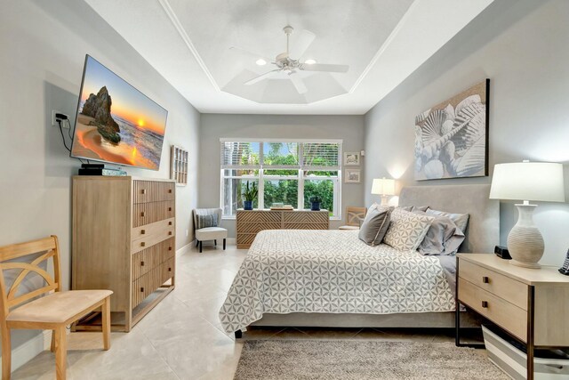 bedroom with baseboards, a raised ceiling, a ceiling fan, and light tile patterned flooring