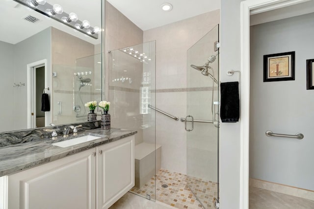 full bath with a stall shower, tile patterned flooring, vanity, and visible vents