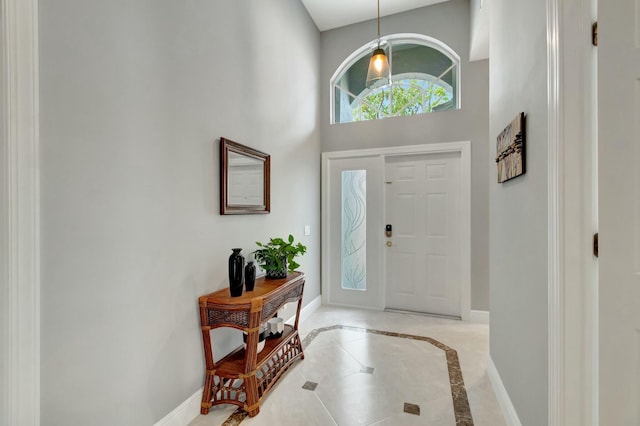 foyer featuring a towering ceiling and baseboards