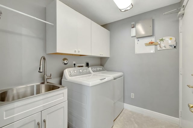 clothes washing area featuring cabinet space, a sink, baseboards, and separate washer and dryer