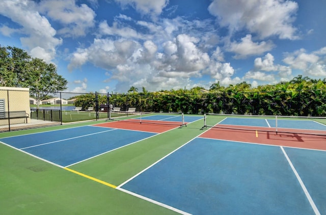 view of tennis court featuring community basketball court and fence