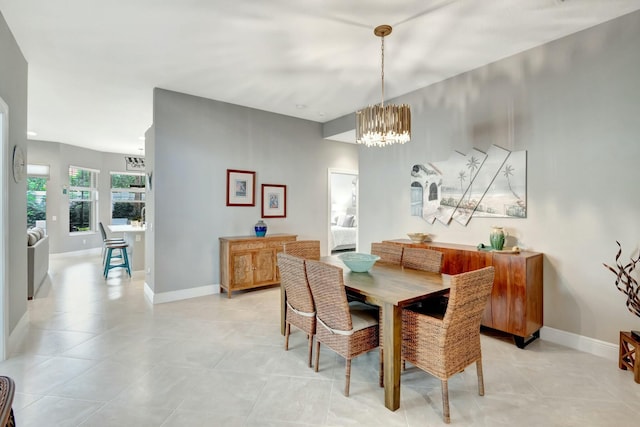 dining room featuring an inviting chandelier, baseboards, and light tile patterned flooring