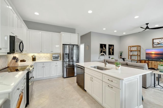 kitchen with stainless steel appliances, a sink, and white cabinets