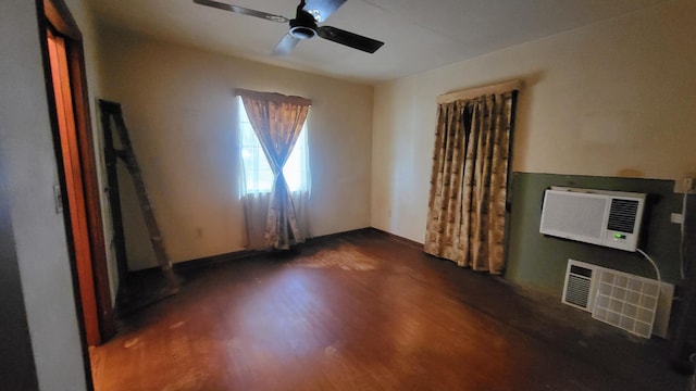 interior space featuring a wall mounted air conditioner, dark wood finished floors, visible vents, and a ceiling fan