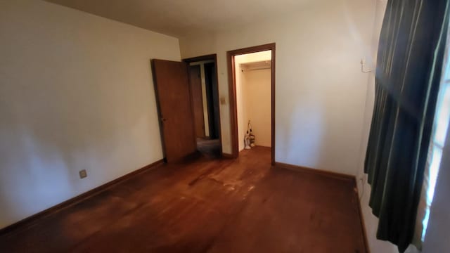 unfurnished bedroom featuring wood finished floors and baseboards