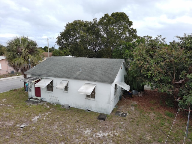 view of front of house featuring entry steps, roof with shingles, and stucco siding