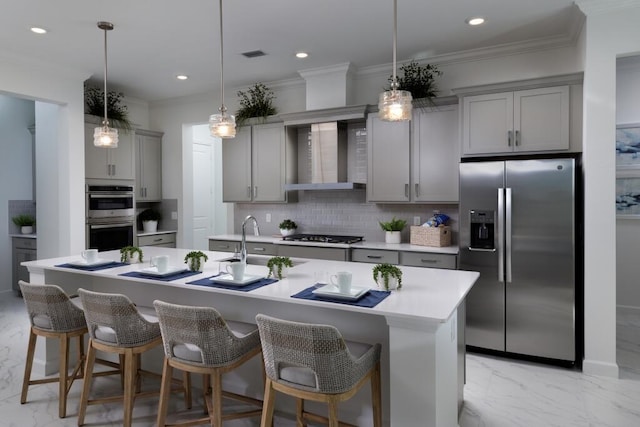 kitchen featuring stainless steel appliances, tasteful backsplash, gray cabinetry, ornamental molding, and wall chimney range hood