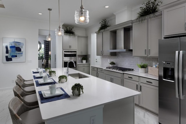 kitchen featuring marble finish floor, gray cabinets, appliances with stainless steel finishes, a sink, and wall chimney range hood