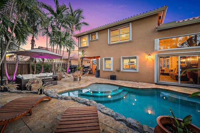 pool at dusk with a patio area, fence, an outdoor hangout area, and a fenced in pool