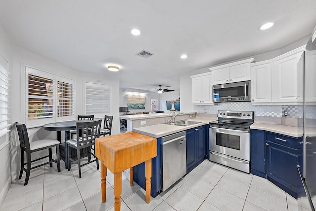 kitchen featuring light countertops, visible vents, appliances with stainless steel finishes, white cabinets, and blue cabinets