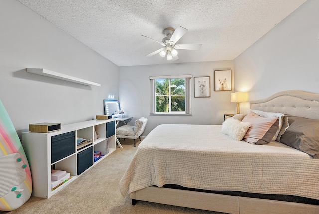 bedroom with a ceiling fan, carpet, and a textured ceiling