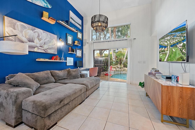 living room with an accent wall, baseboards, a high ceiling, and light tile patterned floors