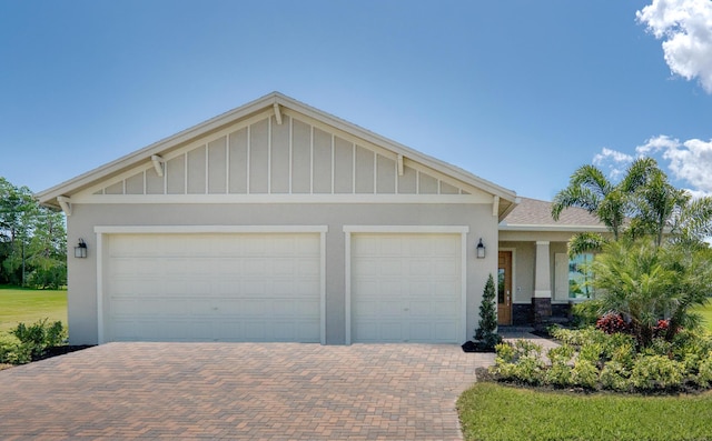 view of front facade with a garage, decorative driveway, and board and batten siding