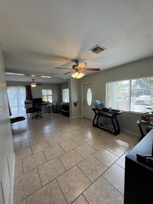 unfurnished living room with baseboards, visible vents, ceiling fan, and light tile patterned floors
