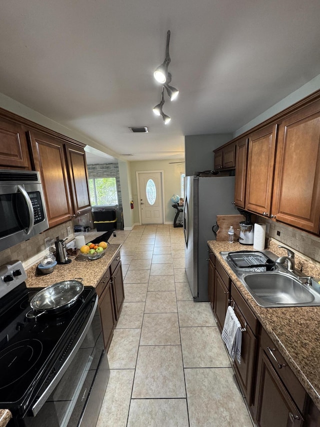 kitchen featuring decorative backsplash, visible vents, appliances with stainless steel finishes, a sink, and light tile patterned floors