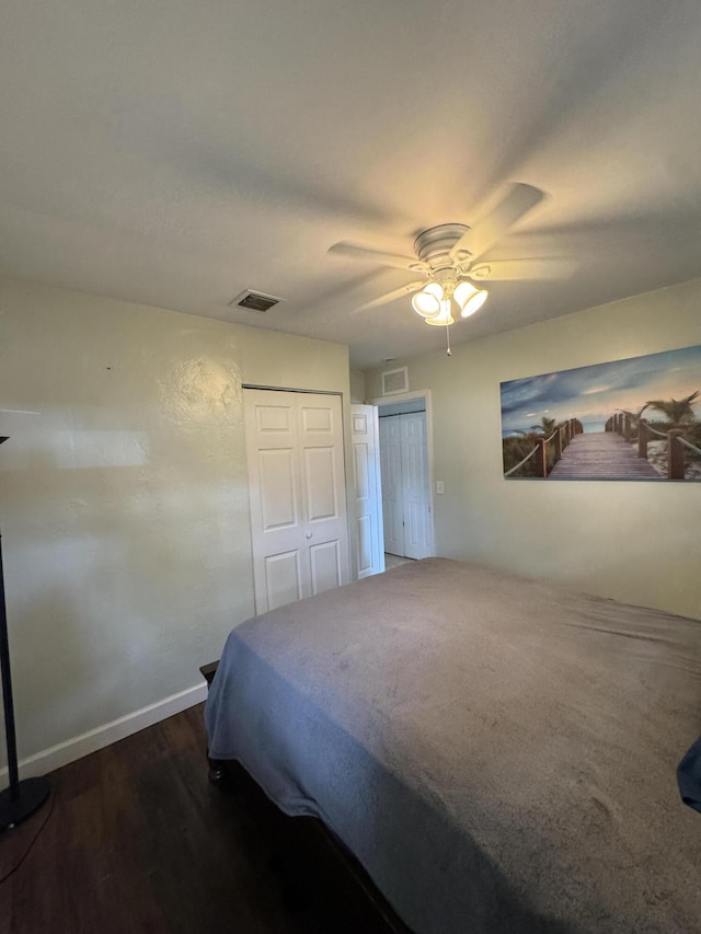 bedroom featuring baseboards, visible vents, a ceiling fan, and wood finished floors