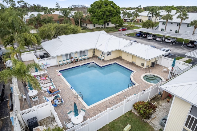 community pool with a patio area, a fenced backyard, and a residential view