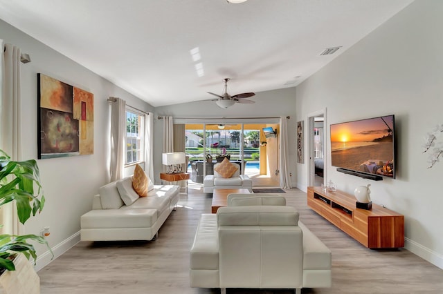 living area with lofted ceiling, light wood-style floors, visible vents, and a healthy amount of sunlight