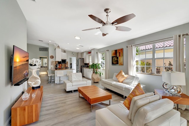 living room with recessed lighting, visible vents, ceiling fan, and light wood-style flooring