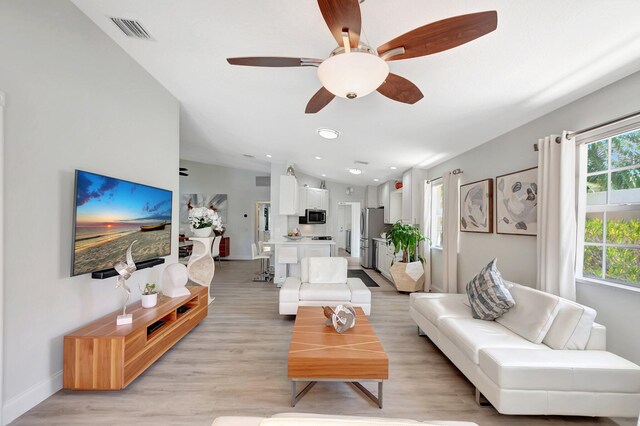 living room with ceiling fan, light wood-style flooring, recessed lighting, visible vents, and baseboards