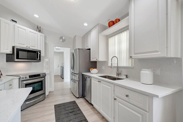 kitchen with visible vents, appliances with stainless steel finishes, a sink, a peninsula, and a kitchen bar