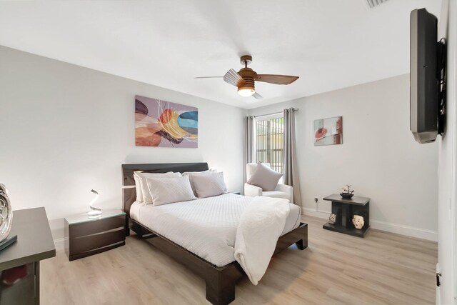 bedroom with ceiling fan, light wood-style flooring, visible vents, and baseboards