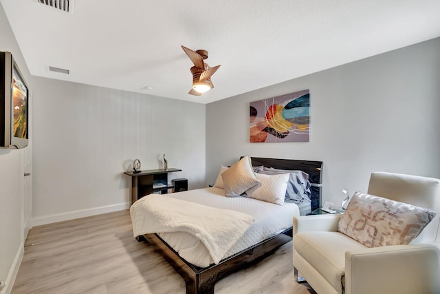 bedroom with visible vents, ceiling fan, light wood-style flooring, and baseboards