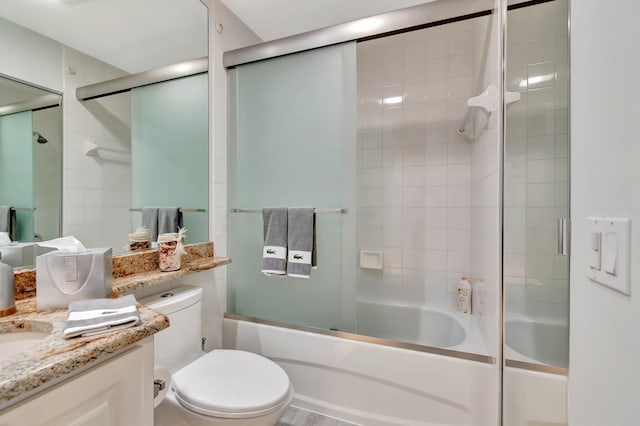 full bathroom featuring shower / bath combination with glass door, vanity, and toilet