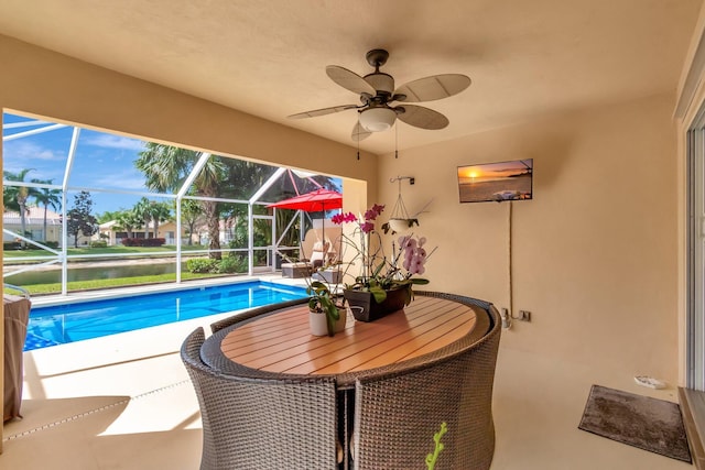 outdoor pool with a patio area, a lanai, and a ceiling fan