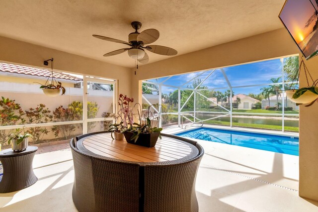 pool with a patio, a water view, and a lanai