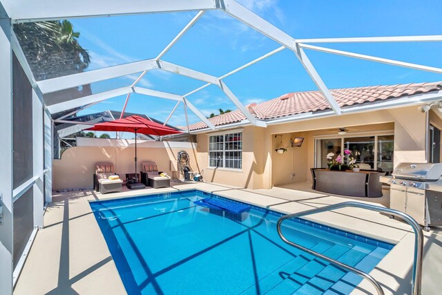 outdoor pool with a water view, glass enclosure, a patio area, and an outdoor hangout area