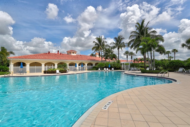 community pool featuring fence and a patio