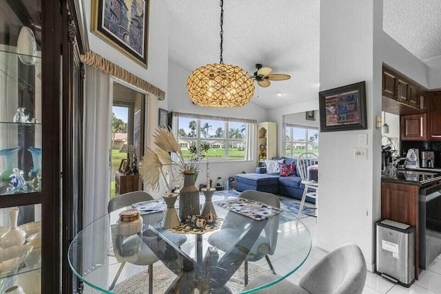 dining space with a textured ceiling, light tile patterned floors, and vaulted ceiling