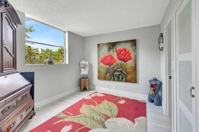 bedroom featuring a textured ceiling and baseboards