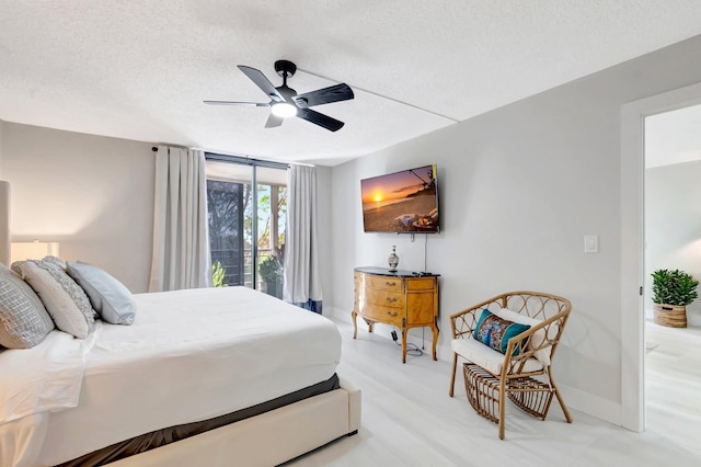bedroom featuring a textured ceiling, baseboards, and ceiling fan