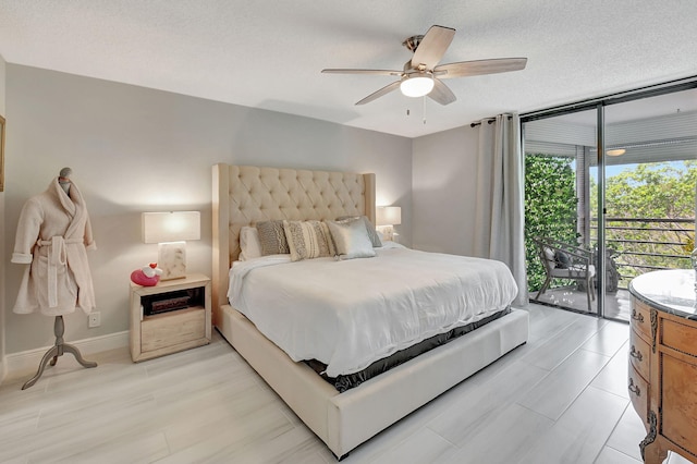 bedroom featuring light wood-style flooring, a textured ceiling, a wall of windows, access to outside, and baseboards