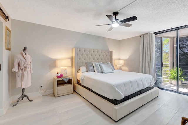 tiled bedroom featuring a wall of windows, ceiling fan, a textured ceiling, and access to exterior