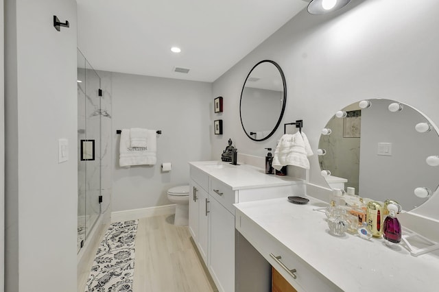 bathroom with a marble finish shower, visible vents, toilet, vanity, and baseboards