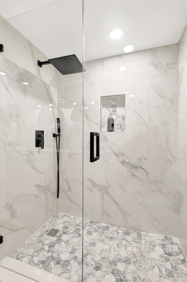 bathroom featuring a marble finish shower