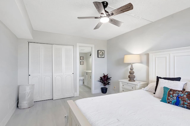 bedroom with connected bathroom, a ceiling fan, a closet, light wood-type flooring, and baseboards